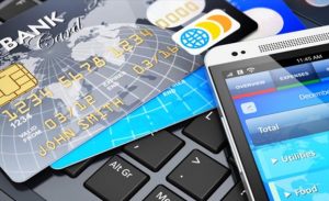 Cartões e celular sobre teclado, tema de produtos bancários
