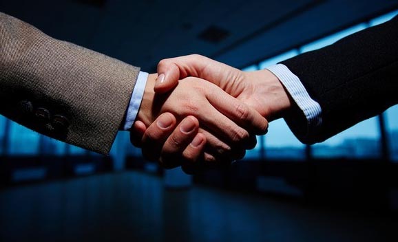 Aperto de mãos em ambiente corporativo